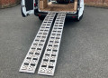 Pair of aluminium loading ramps resting on van