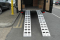Pair of aluminium loading ramps resting on vehicle