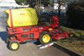Ride-on mower driving on ramp onto kerb 