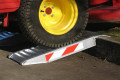 Ride-on mower using kerb ramp to overcome kerb 