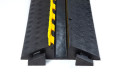 Open lid on the black and yellow rubber cable protector with antislip chequered surface