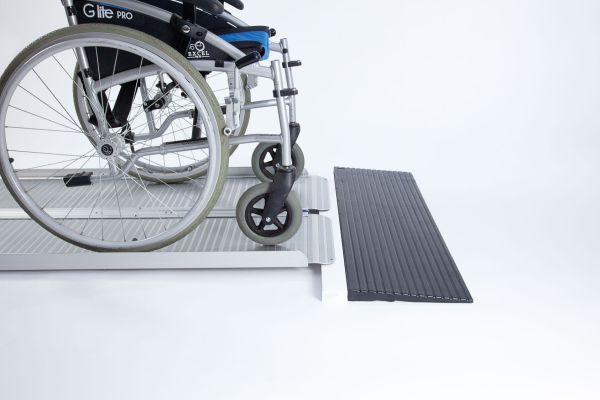 Manual wheelchair going up ramp onto threshold