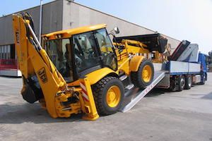 Tractor digger driving on to tipper truck