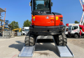 Digger driving up alloy vehicle ramps 
