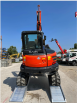 Digger driving up a pair of alloy ramps 