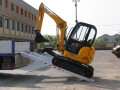 Mini digger driving up loading ramps 