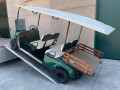 Gold buggy driving up pair of ramps 