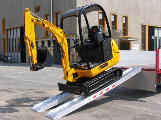 Mini digger driving down ramps 