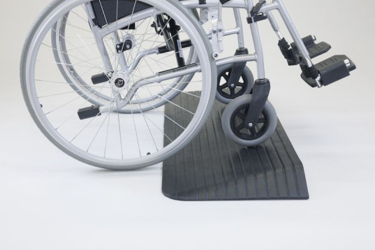 Wheelchair on rubber threshold ramp 