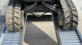 Rubber tracked digger going up alloy ramps 