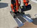 Digger driving up alloy ramps