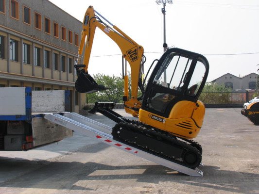 Mini digger on loading ramps