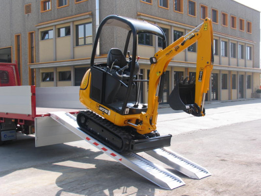 Mini digger on aluminium ramps