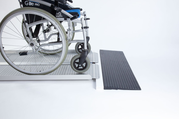 Manual wheelchair going up ramp onto threshold