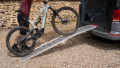 Motorbike loading ramp resting on boot of car with bike being loaded