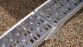 Motorbike loading ramp resting on boot of car, close up of surface
