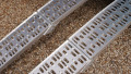 Pair of motorbike loading ramps resting on vehicle boot, close up of surface
