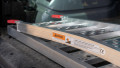 Single aluminium lightweight motorcycle ramp folded up and stored in the boot of a vehicle