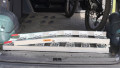 Single aluminium lightweight motorcycle ramp folded up and stored in the boot of a vehicle