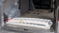 Single motorbike ramps with support legs resting folded up and stored in the boot of a vehicle
