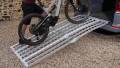 extra wide motorbike loading ramps resting on car with bike being loaded