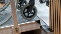 Wheelchair ramp with handrails with wheelchair going up onto a step