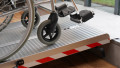 Aluminium wheelchair ramp resting on a step with wheelchair on the ramp 