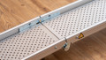 Close up of the folding hinge of low Profile Edge Channel Ramps resting on a step used for a wheelchair or mobility scooter