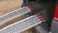 Pair of motorbike loading ramps resting on vehicle boot, close up of rest on connection