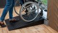 pair of rubber threshold ramps in use with manual assisted wheelchair