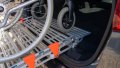 manual wheelchair being pushed up a rollable ramp into the boot of a car - close up of the rest on connection