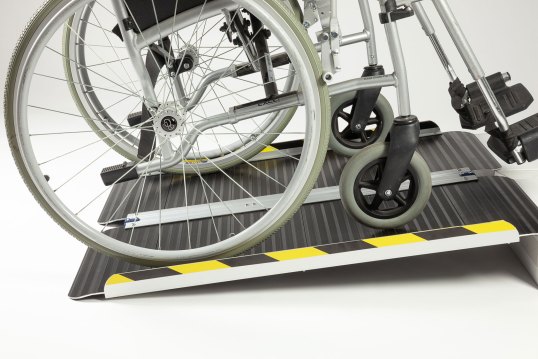 Wheelchair going up 4ft wheelchair ramp with black surface 