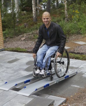 Wheelchair user going up premium channel ramps