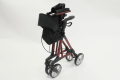 Folded four wheeled red rollator