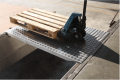 Pallet truck crossing loading bridge 