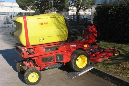 Ride on mower driving up kerb using a pair of aluminium container ramps