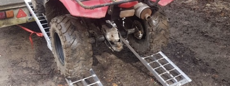 quad bike riding up a pair of bike ramps