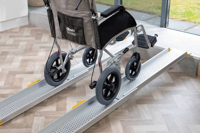 Wheelchair going up a pair of telescopic wheelchair ramp