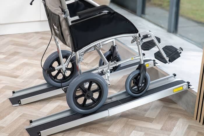 Manual wheelchair going up telescopic ramps 