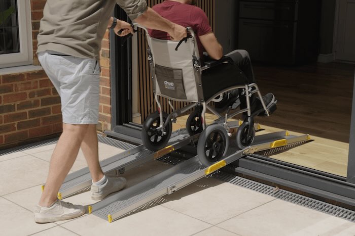 Manual wheelchair using telescopic wheelchair ramps to overcome upvc doorway