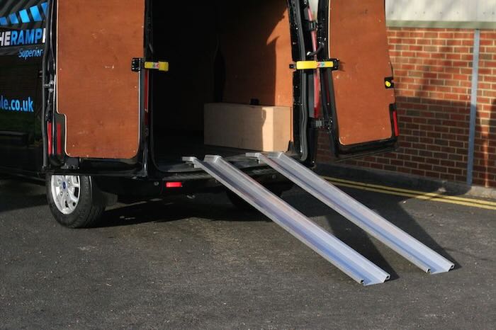 Pair of aluminium van ramps resting on back of van Pair of aluminium van ramps resting on back of van