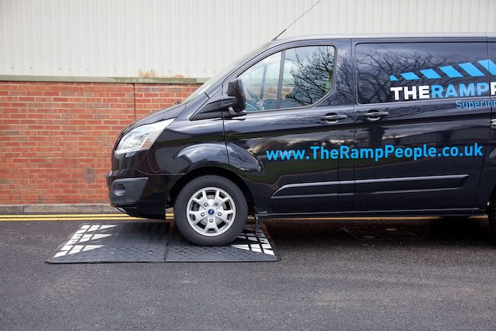 Van driving over black speed cushion Van driving over black speed cushion