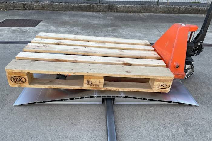 Pallet truck driving over bridge ramp 