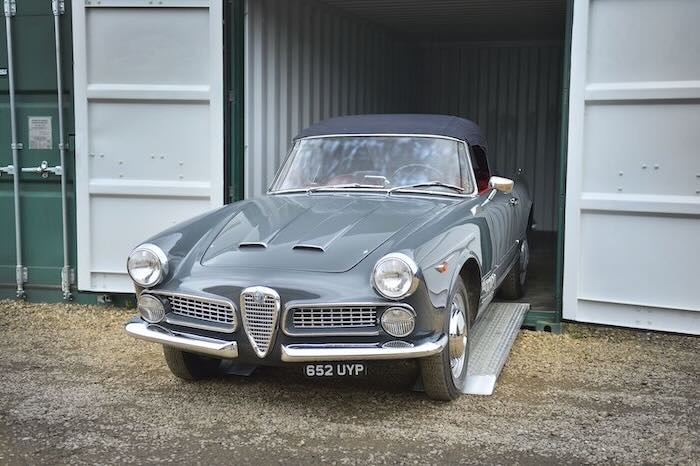 Car using a pair of car ramps to exit a container
