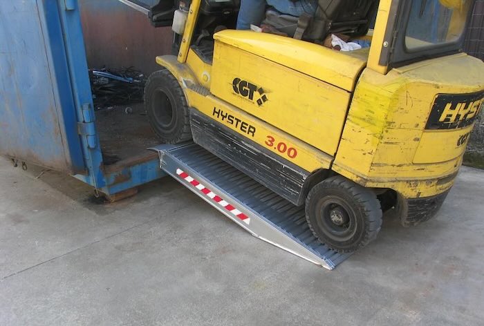 Forklift driving up container ramps 