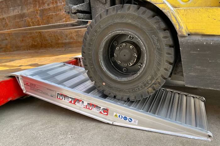 Forklift driving up container ramps 