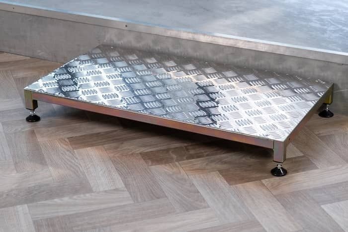 Metal adjustable half step infront of a step