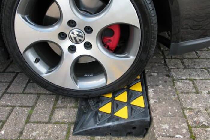 Kerb ramp with car driving up it Kerb ramp with car driving up it