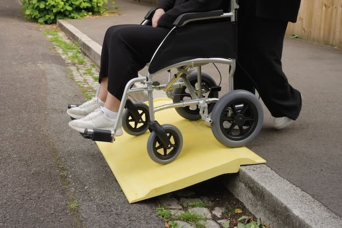 Wheelchair going down yellow kerb ramp Wheelchair going down yellow kerb ramp