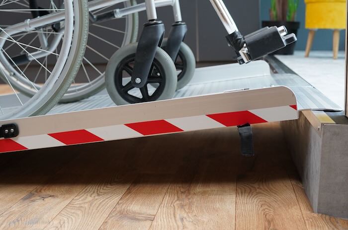 Wheelchair going up ramp onto step